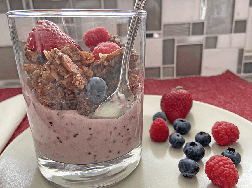 Photo of a yogurt and JuNũla Just Nuts Granola parfait with fresh berries on a plate