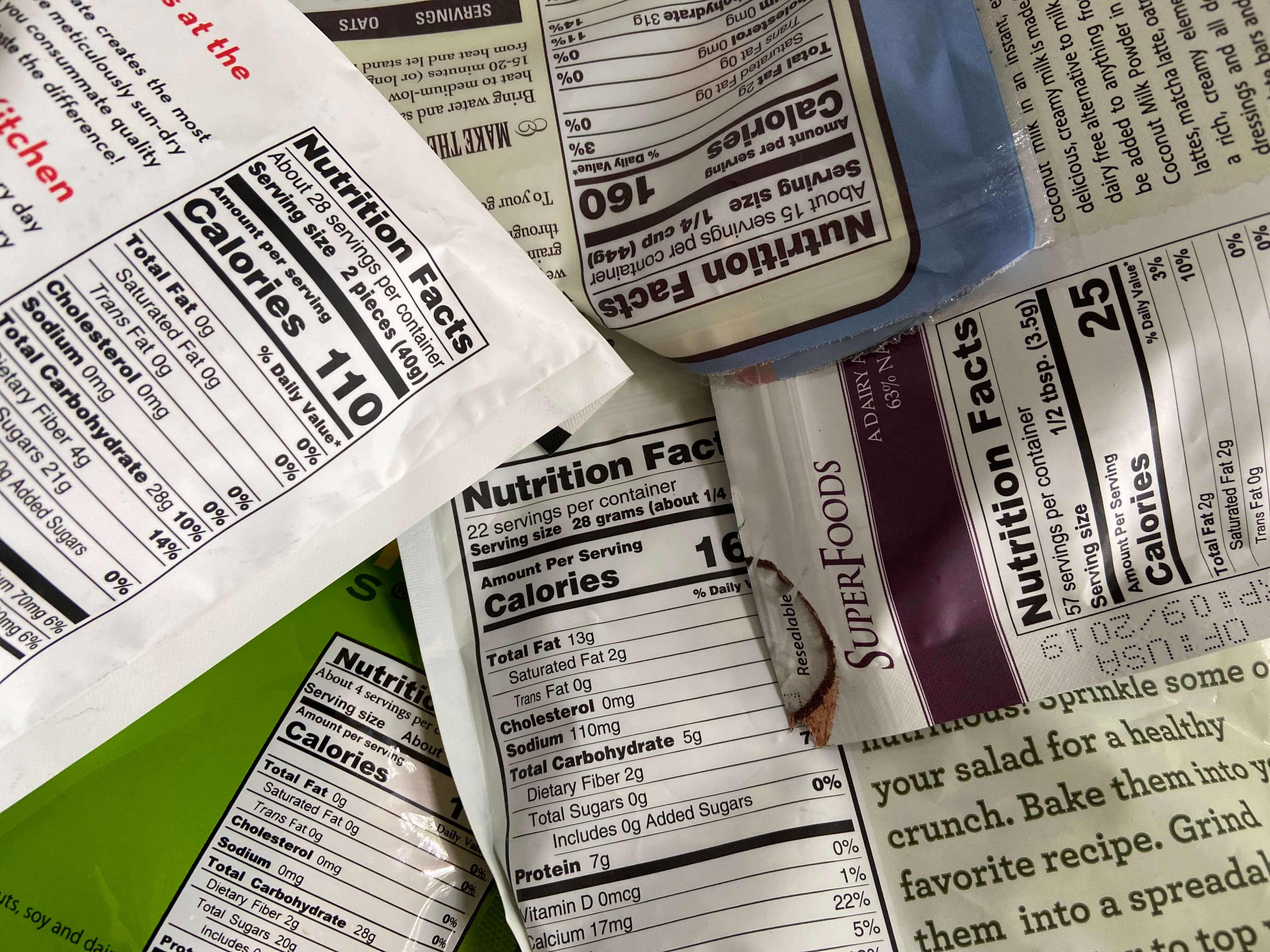 Picture of a bunch of nutrition labels which need to be read to ensure they are gluten free grain free low carb choices like JuNula just nuts granola is