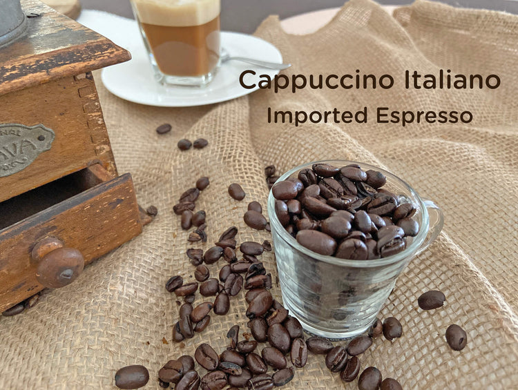 Photo of an antique coffee grinder with coffee beans and a cup of cappucino